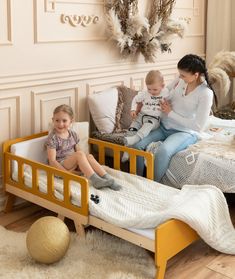 a woman and two children sitting in a bed