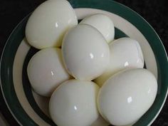 several white eggs in a green and white bowl