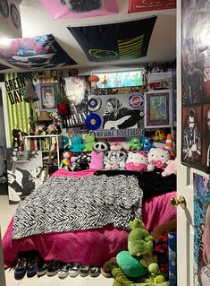 a room filled with lots of stuffed animals and posters on the wall above it's bed