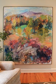 an abstract painting hangs in the corner of a room