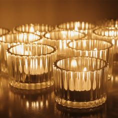 many lit candles sitting on top of a table