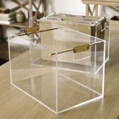 two clear boxes sitting on top of a wooden table