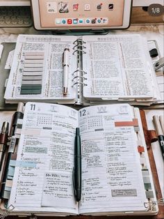 an open book sitting on top of a desk next to a laptop computer and pen