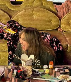 a woman sitting at a table with food in front of her