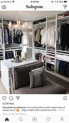 an organized closet with clothes and chandelier