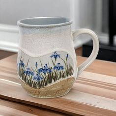 a ceramic mug with blue flowers painted on it