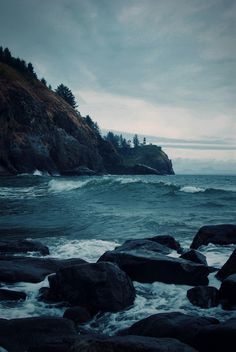 an image of the ocean with rocks in front of it and a triangle on top