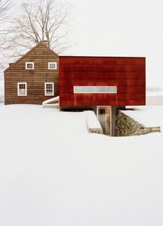 two houses in the snow one has a red structure on it's roof and is surrounded by trees