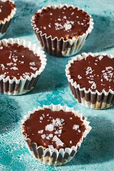 chocolate cupcakes with white frosting and sprinkles on blue background