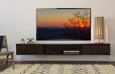 a flat screen tv sitting on top of a wooden entertainment center in a living room