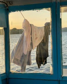 clothes hanging out to dry in the sun on a boat at sea with water behind them