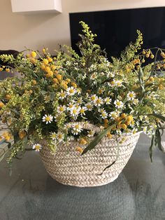 a basket filled with lots of yellow and white flowers