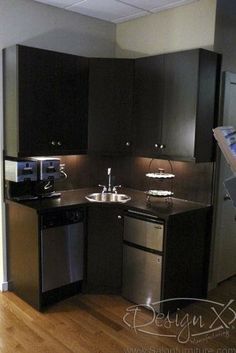 a kitchen with black cabinets and stainless steel appliances