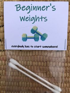 two white toothbrushes sitting on top of a brown carpet next to a sign that says beginner's weights