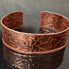 a close up of a metal bracelet on a table