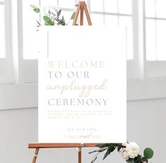 a welcome sign on an easel with flowers