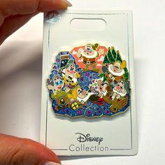 someone is holding up a disney pin