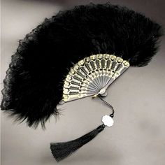 a black feather fan with a white flower on it