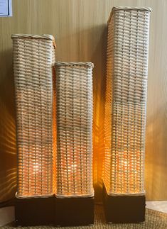 two wicker vases sitting next to each other on top of a rug in front of a wall