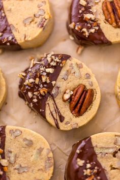 chocolate covered cookies with pecans and nuts on top are sitting on wax paper, ready to be eaten