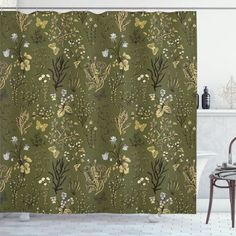 a green shower curtain with flowers and leaves on it in a bathroom next to a bathtub