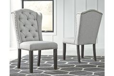 two upholstered chairs sitting on top of a rug