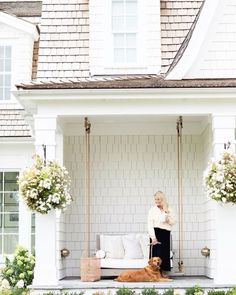 a woman sitting on a porch swing with her dog