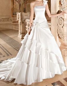 a woman in a white wedding dress posing for the camera