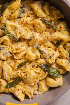 a pan filled with pasta and sauce on top of a table