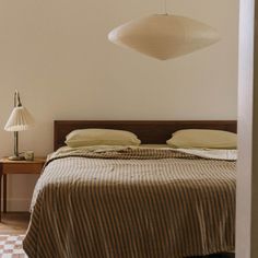 a bed sitting in a bedroom next to a lamp