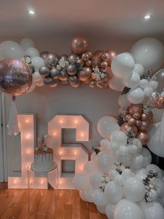 a room filled with balloons and white letters