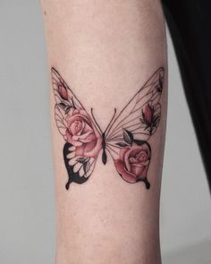 a woman's leg with a butterfly and roses tattoo on the left side of her arm