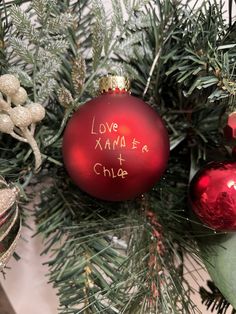 red christmas ornament with children's handwriting on it