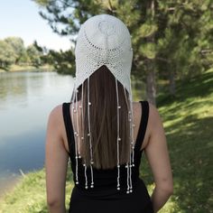 the back of a woman wearing a white crochet hat with pearls on it