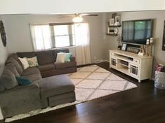 a living room filled with furniture and a flat screen tv on top of a wooden floor