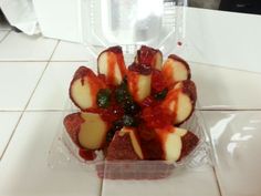 a plastic container filled with sliced fruit on top of a counter