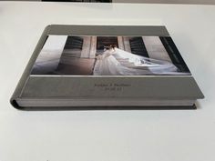 a wedding photo is placed on top of a white table with a black and silver frame