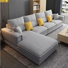 a large gray couch with yellow pillows in a living room