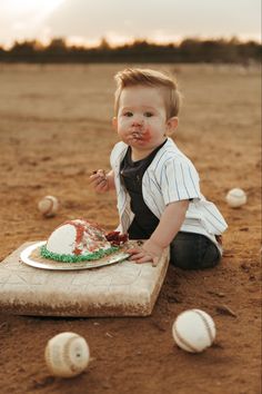 a little boy sitting on the ground eating cake