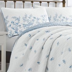 a white bed with blue flowers on it