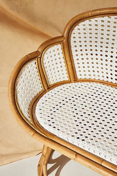 a wicker chair sitting on top of a white floor next to a tan wall