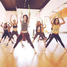 a group of young women standing on top of a wooden floor in front of a mirror