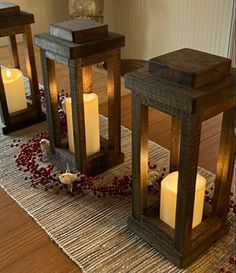 three lit candles sitting on top of a wooden table