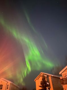 an aurora bore in the sky over houses