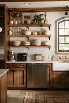 a kitchen with wooden cabinets and open shelving above the dishwasher is shown