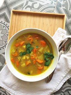 a white bowl filled with soup on top of a wooden tray