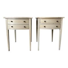 two white wooden tables with drawers on each side