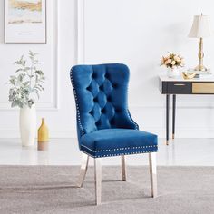 a blue chair sitting in front of a table with a vase on top of it