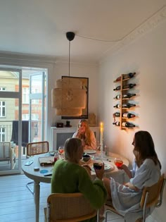 three women sitting at a table drinking wine