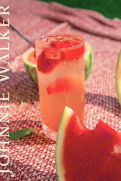 a watermelon drink sitting on top of a table next to slices of watermelon